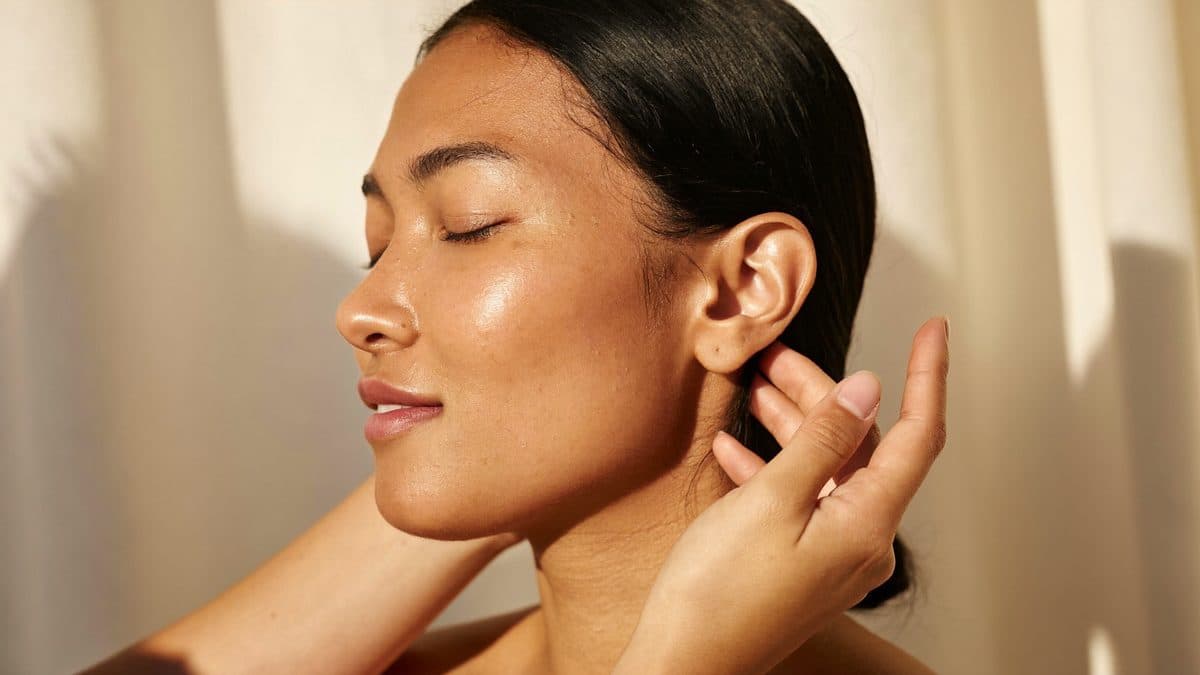 Massage Kobido du visage, mains expertes sur un visage détendu dans une lumière douce